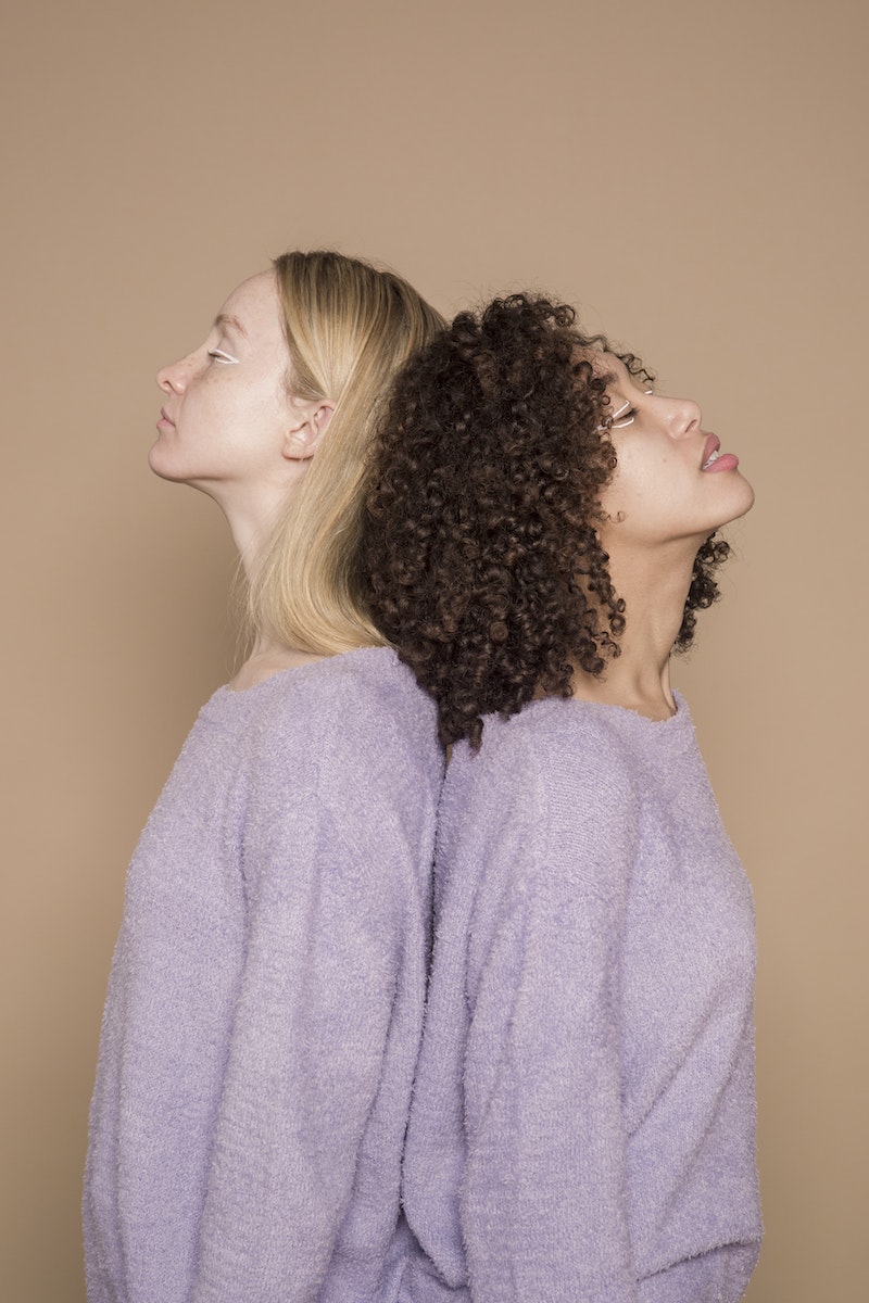 Side view of diverse exhausted friends with extraordinary makeup on beige background of studio