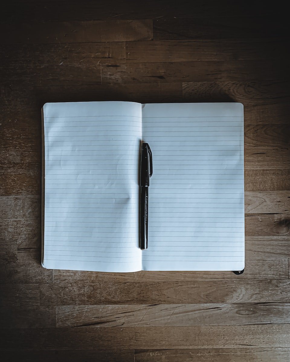 notes black click pen on white notebook