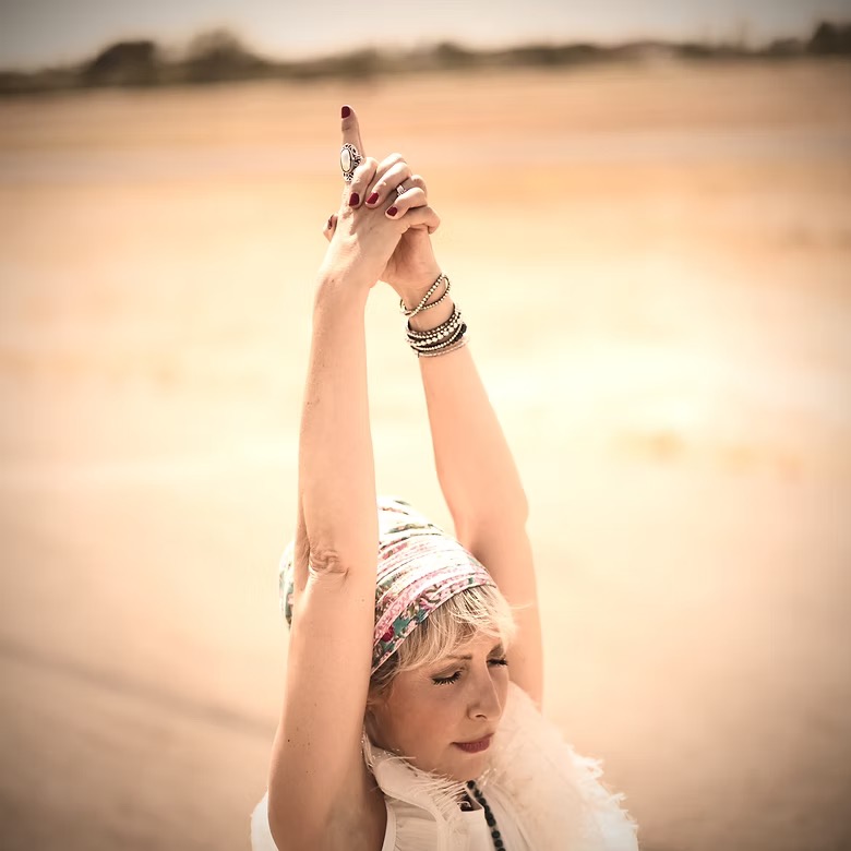 Yoga Kundalini Montpellier A cheerful woman in active wear exercises with a yoga ball indoors, promoting wellness.